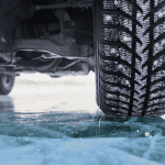 Rear of front driver tire, driving on snow.